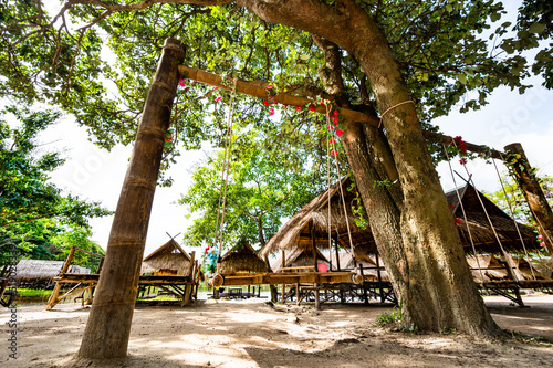Fotografie, Obraz Wood swing with hut beside Huay Tung Tao Lake
