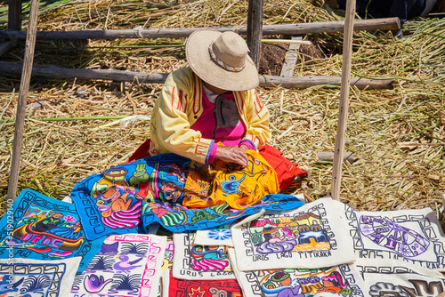 Traditional woman weaving fabrics on Floating islands Titicaca lake, Peru photo
