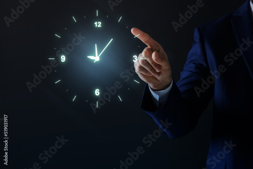 Man holding virtual icon of clock on dark background, closeup. Time management photo