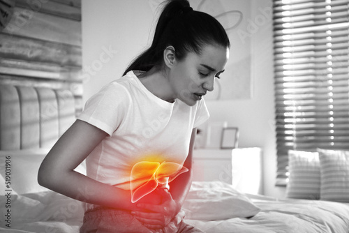 Sick woman suffering from pain in bedroom and illustration of unhealthy liver. Hepatitis disease