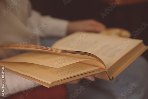Woman reading book in room, closeup view