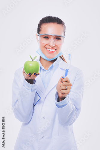 Dentist medical doctor woman hold green fresh apple in hand and tooth brush. Dentist doctors. Woman doctors