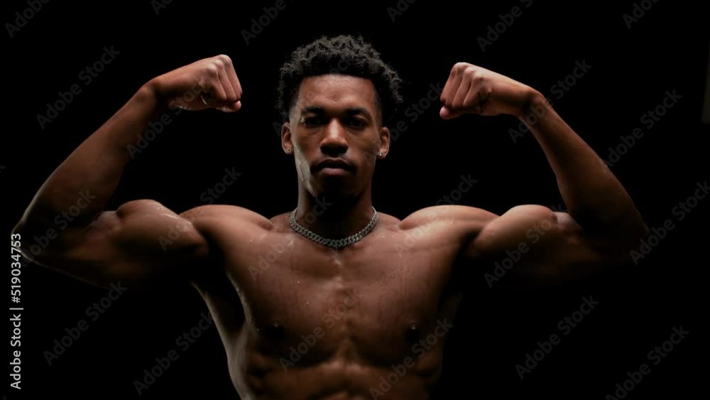 Muscular man showing muscles. African American male posing against black background. Muscular man showing muscles. African American male posing against black background.