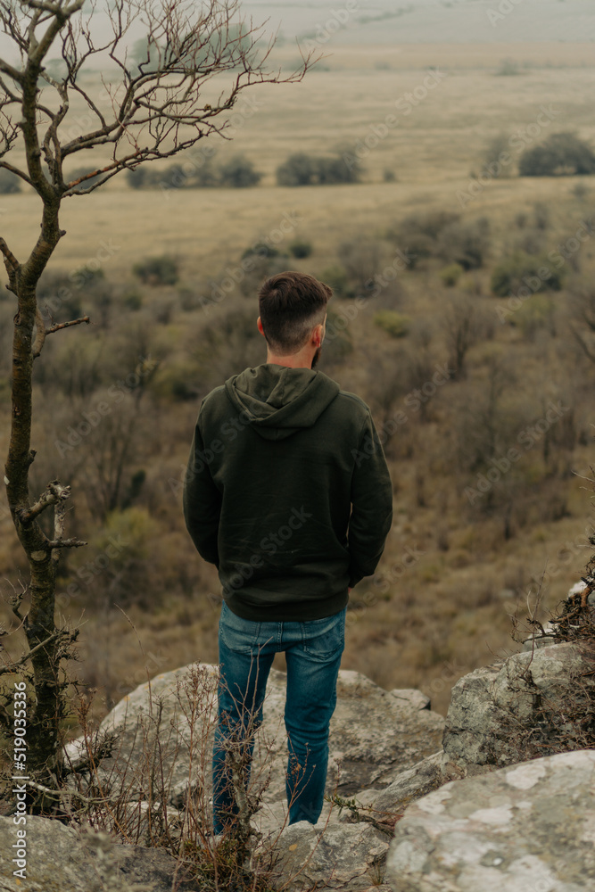 Naklejka premium Young man looking at a landscape from the heights