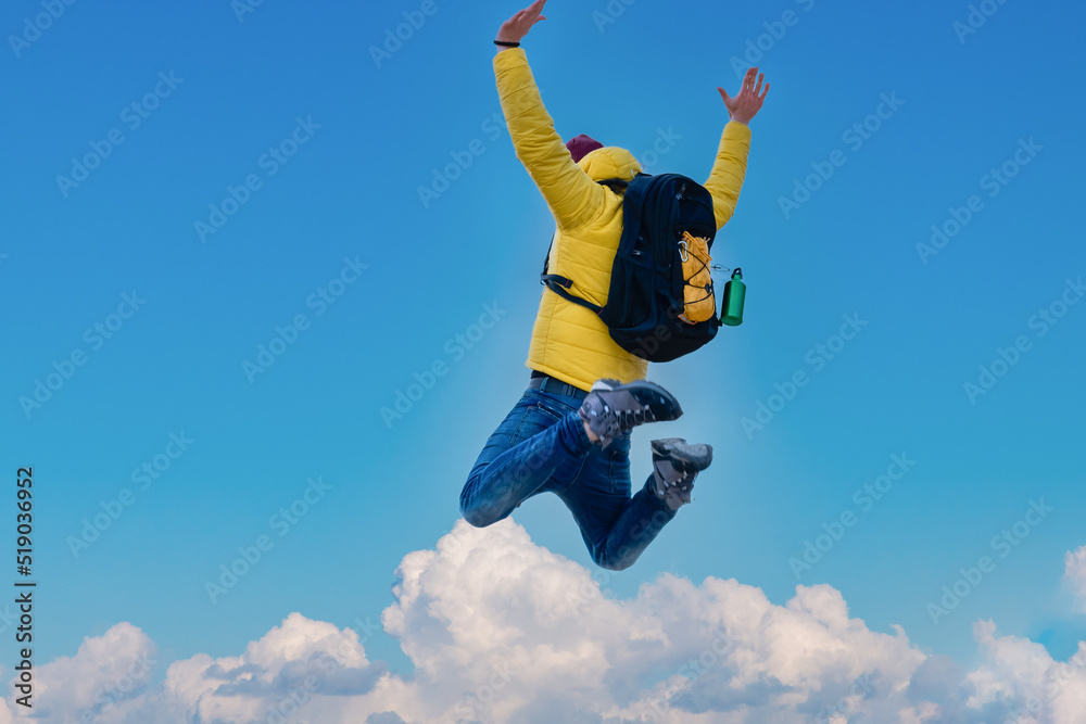 Hiker with backpack raising arms jumping on the top of a mountain - Successful man with arms up enjoying victory - Selective focus. Hiker with backpack raising arms jumping on the top of a mountain - Successful man with arms up enjoying victory - Selective focus.