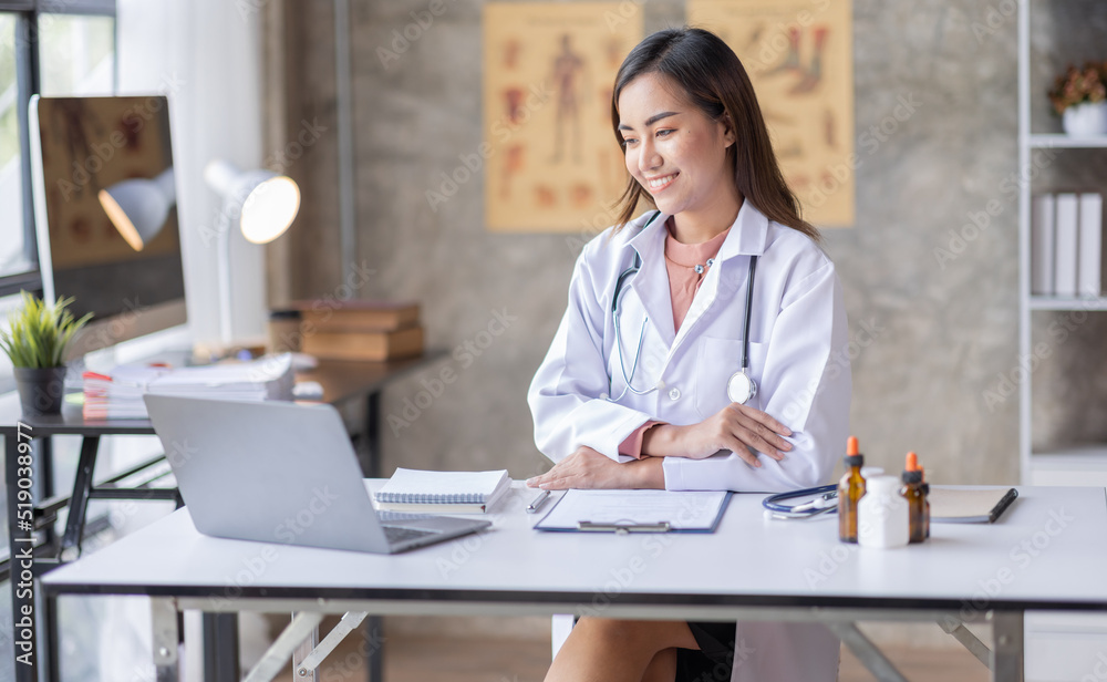Portrait of a beautiful Youn Asian female doctor sitting in medical office Portrait of a beautiful Youn Asian female doctor sitting in medical office