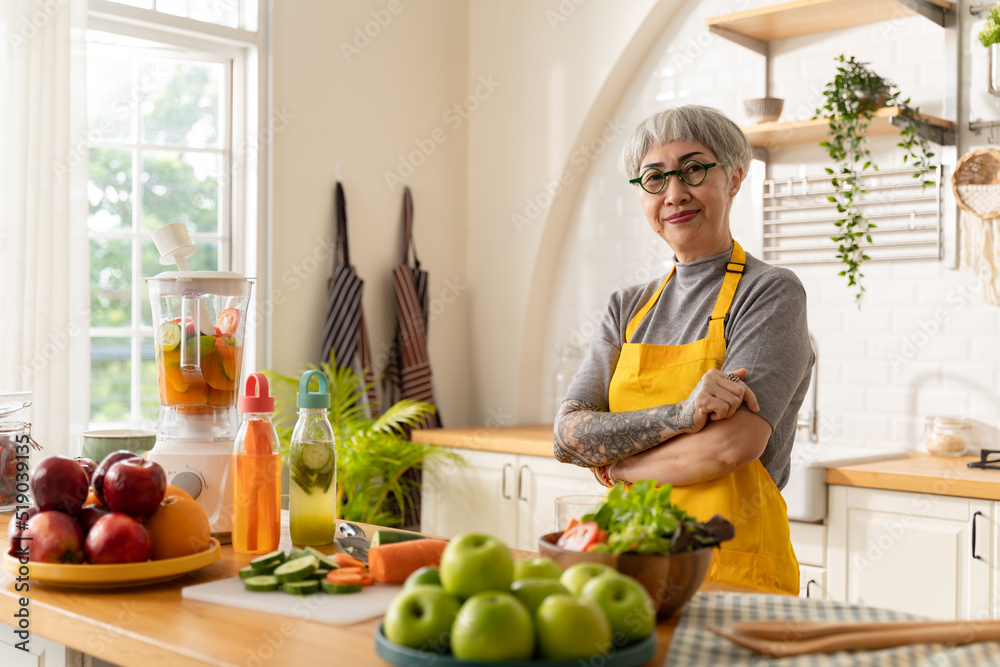 senior tattoo female preparing infused water,healthy vegetarian with fruits and vegetables in kitchen room at home.Old cheerful people taking care about nutrition,Health care,vegan concept. senior tattoo female preparing infused water,healthy vegetarian with fruits and vegetables in kitchen room at home.Old cheerful people taking care about nutrition,Health care,vegan concept.