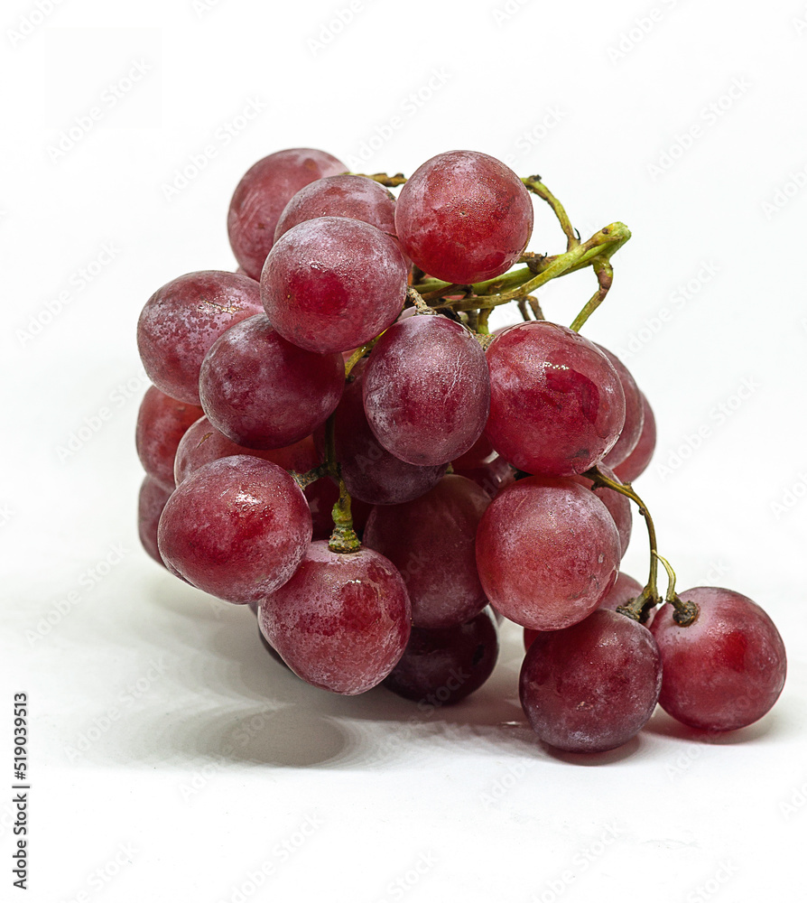 Purple fresh and wet grapes on white background