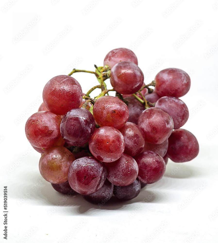 Purple fresh and wet grapes on white background