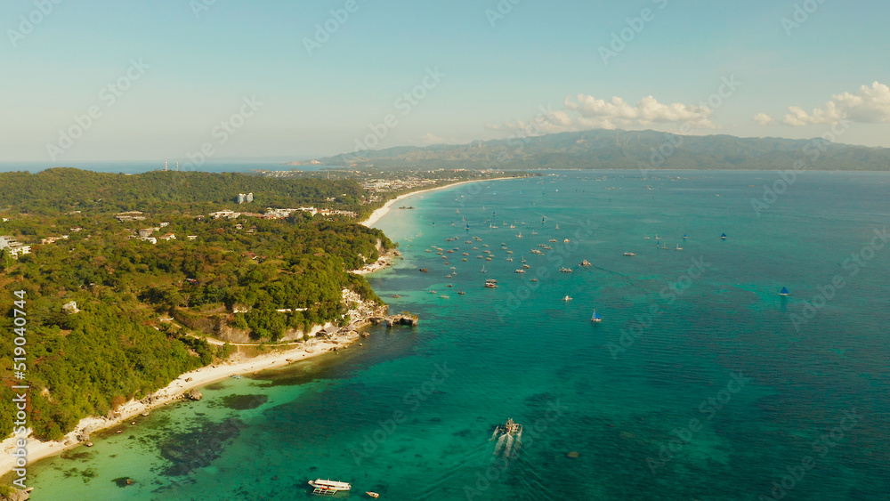 White sandy beach with turquoise water and tourists on Boracay Island, top view. Tropical white beach with sailing boat. Summer and travel vacation concept.