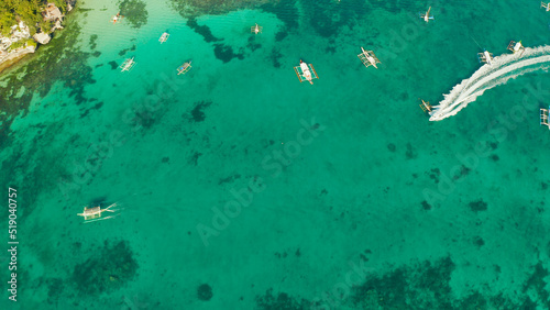 Tropical landscape boats in the turquoise lagoon and tropical beach from above. Seascape with beach on tropical island. Summer and travel vacation concept. Boracay Island, Philippines