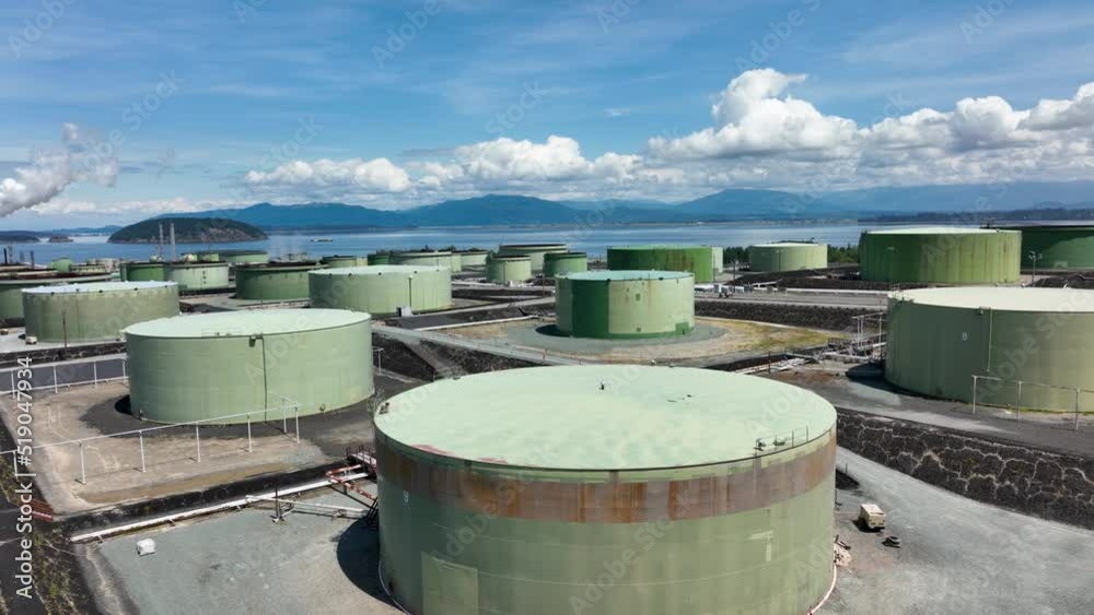 Aerial shot above a large petroleum tank at the March Point refinery in Anacortes, WA. Shot zooms out to show the environmental proximity to cows.