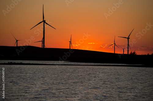 Wind turbines against the background of the red sky.