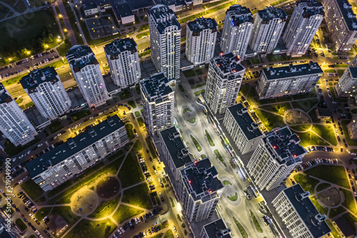 residential district with illuminated high-rise apartment buildings at night. aerial view.