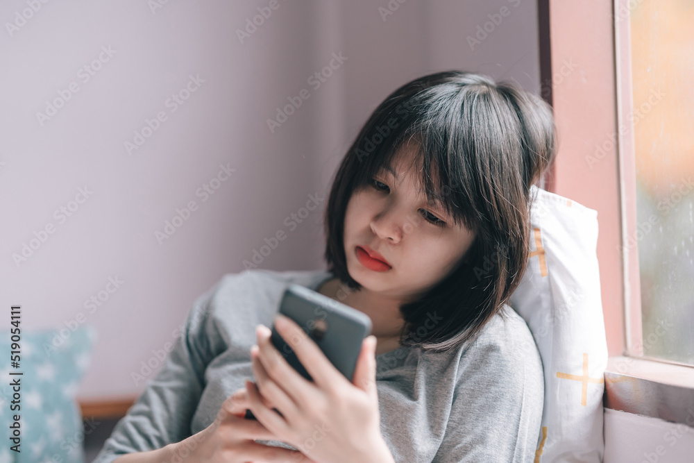 Woman looking at phone with a despairing expression. Woman looking at phone with a despairing expression.