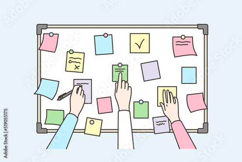 Colleagues brainstorm using sticky notes on board