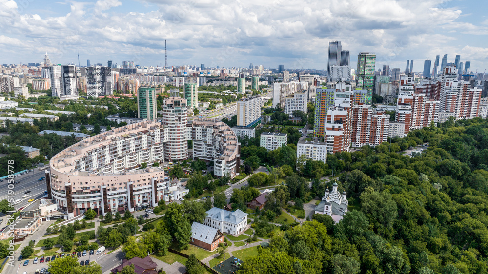 panoramic view of the cityscape with high-rise buildings, freeways and green parks on a sunny day taken from a drone