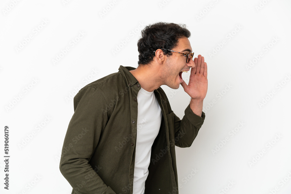 Caucasian handsome man over isolated white background shouting with mouth wide open to the side Caucasian handsome man over isolated white background shouting with mouth wide open to the side
