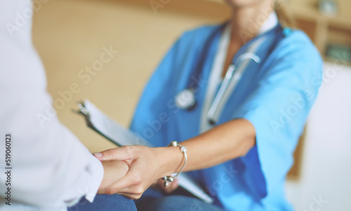 Woman doctor helping senior holding hand in hospital