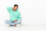 Caucasian handsome man sitting on the floor with neckache