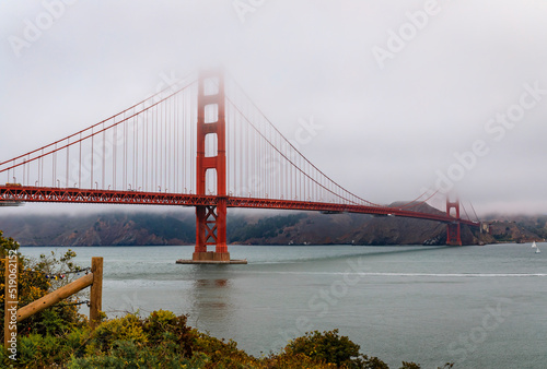 The famous Golden Gate bridge on a cloudy summer day with low hanging fog rolling in San Francisco, California © SvetlanaSF
