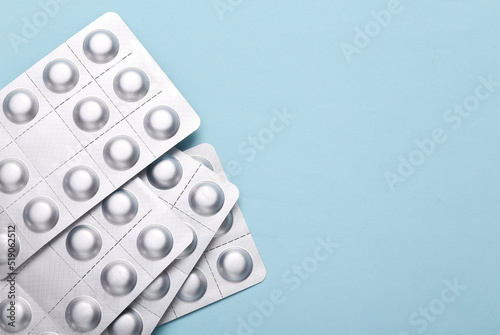 Fotografie Metal blisters pills on a blue background. Copy space. Top view