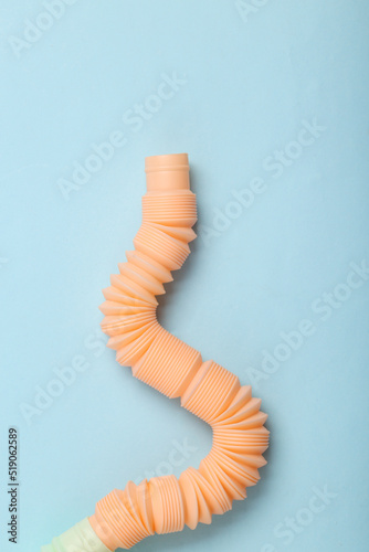 Antistretch pop tube toy on blue pastel background. Top view photo