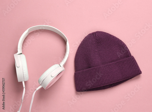 Beanie and stereo headphones on a pink background. Youth party, music concept