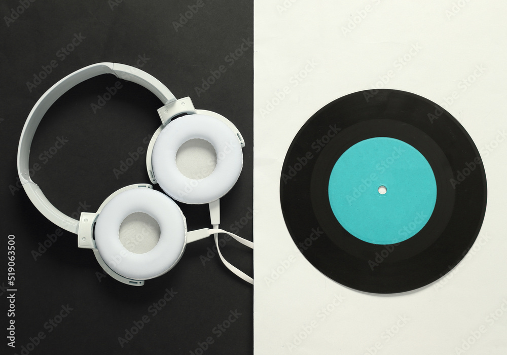 Stereo headphones and vinyl record on white black background. 80s. Flat lay. Top view Stereo headphones and vinyl record on white black background. 80s. Flat lay. Top view