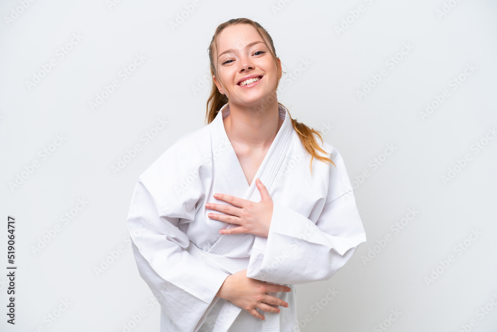 Young caucasian girl doing karate isolated on white background smiling a lot Young caucasian girl doing karate isolated on white background smiling a lot
