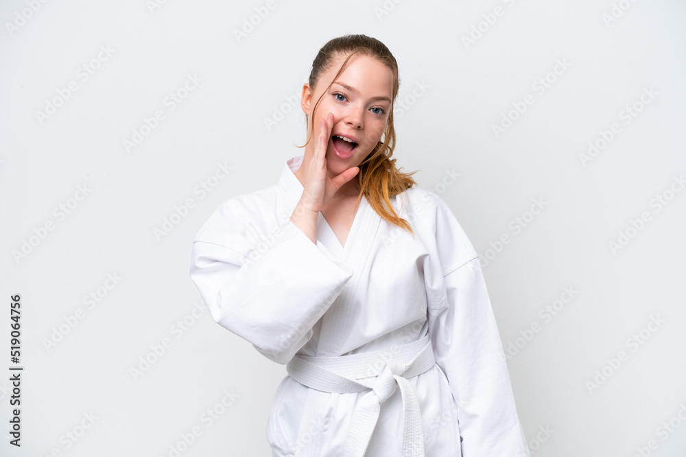 Young caucasian girl doing karate isolated on white background shouting with mouth wide open Young caucasian girl doing karate isolated on white background shouting with mouth wide open