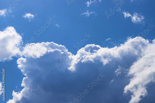 White thick and fluffy cumulus clouds in the blue sky, close up. Beautiful cloudscape