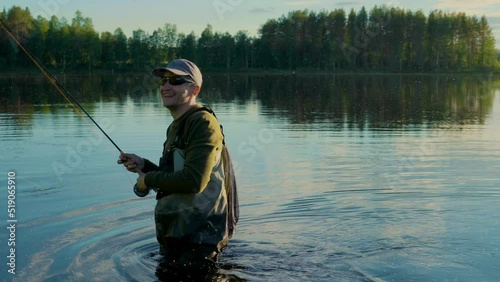 At sunset in the lake, a man is fly-fishing in the river.