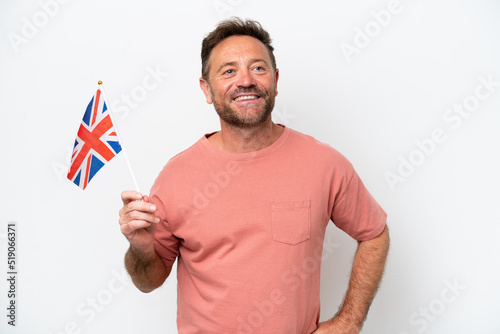 Middle age caucasian man holding English flag isolated on white background posing with arms at hip and smiling