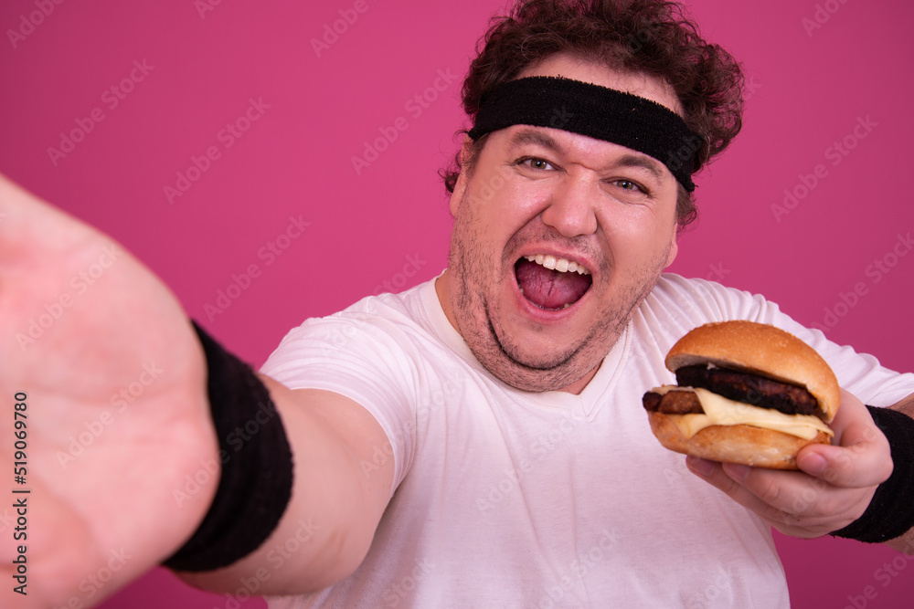 Diet, fitness and healthy lifestyle. Funny fat man eating a burger.	