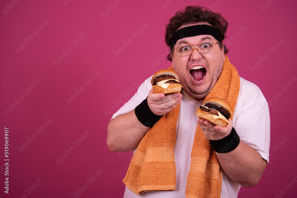 Diet, fitness and healthy lifestyle. Funny fat man eating a burger. Diet, fitness and healthy lifestyle. Funny fat man eating a burger.