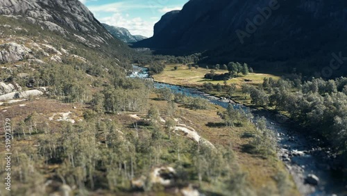 Aerial view of the river flowing through the wide rocky valley. Pan forward. photo