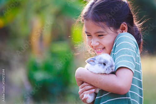 фотографія Asian child girl holding and hugging her adorable bunny fluffy with tenderness and love