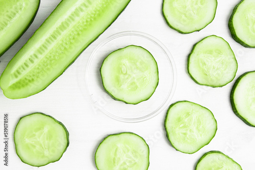 Fresh cucumber slices on white wooden background top view. Green vegetables to nourish and moisturize the skin.