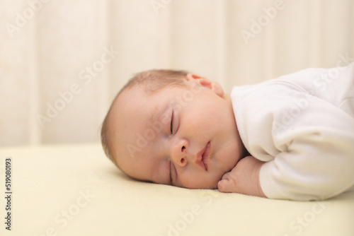 The baby sleeps in the copy space crib . Advertising of children's goods. Illustrating children's articles. A small child. A newborn.
