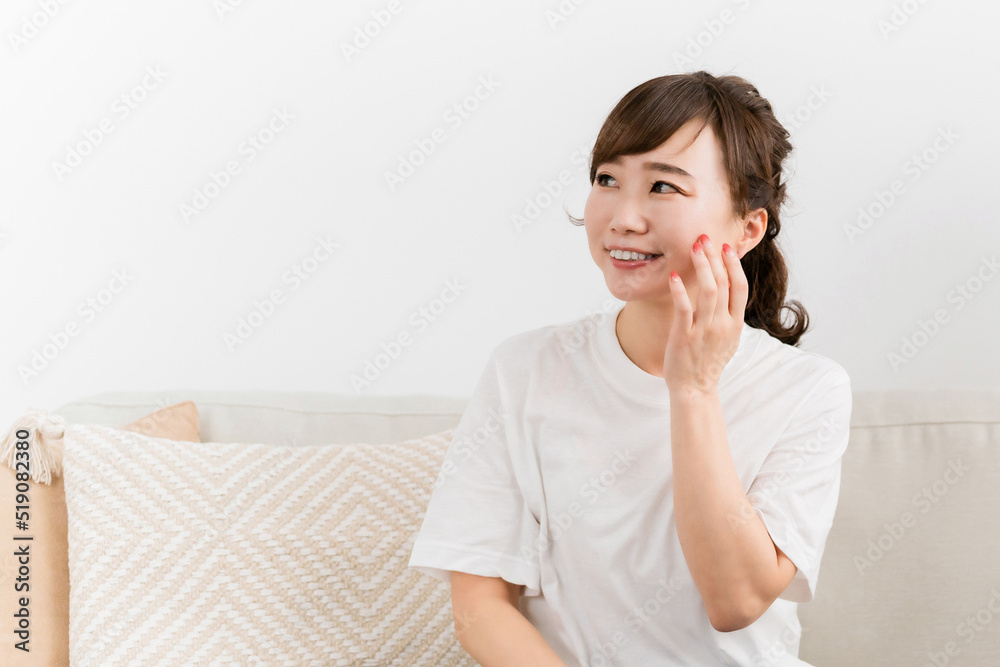 ソファに座りながら肌を触る女性(スキンケア)
ソファに座りながら肌を触る女性(スキンケア)