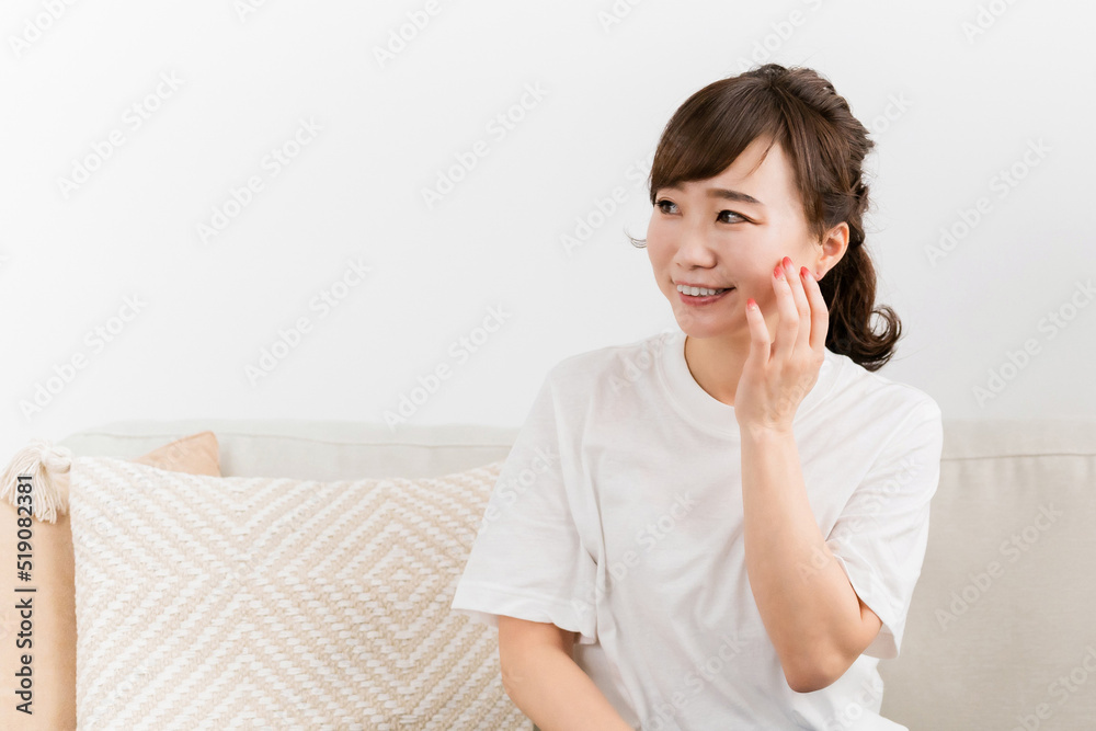 ソファに座りながら肌を触る女性(スキンケア)
ソファに座りながら肌を触る女性(スキンケア)