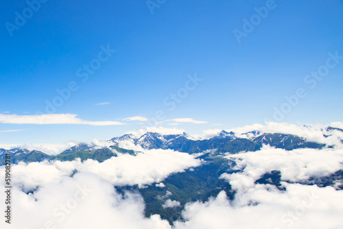 mountain peaks above the clouds on a sunny summer day © yta