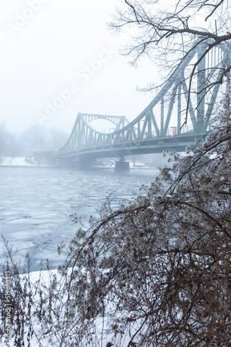 Germany, Brandenburg, Potsdam, Ice floating in river Havel with Glienicke Bridge in background photo