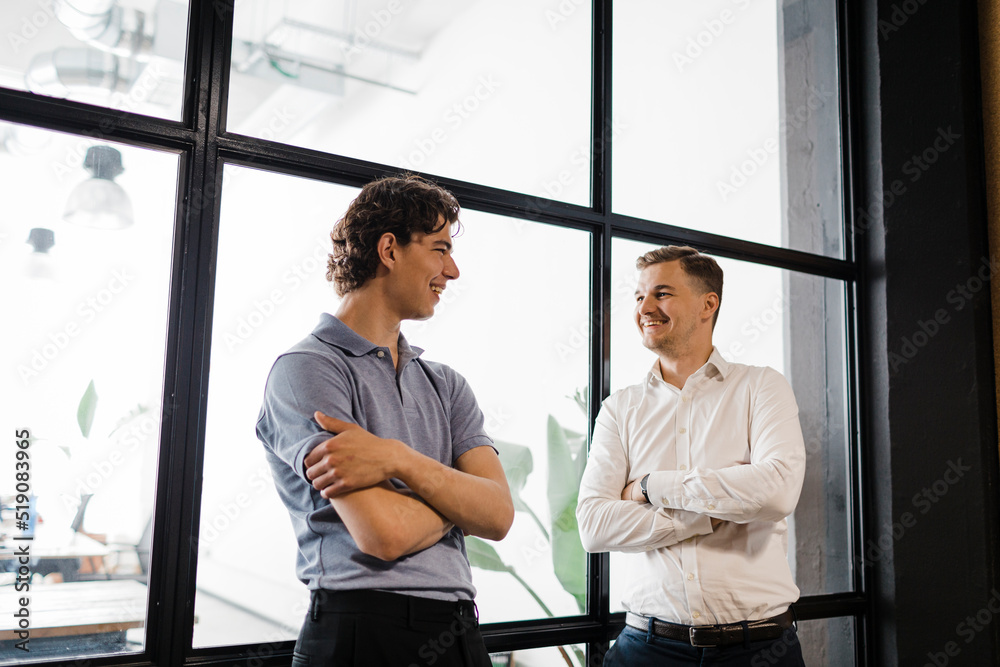 Young businessman talking with colleague in office Young businessman talking with colleague in office