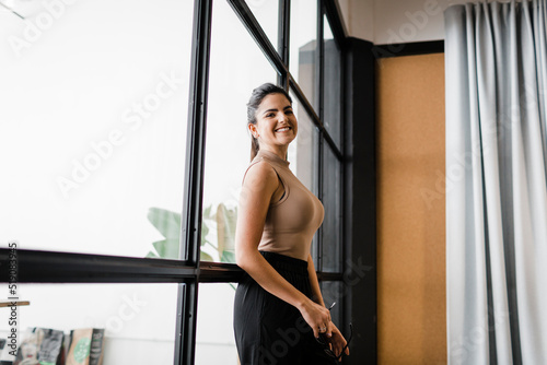 Happy young businesswoman standing in modern office photo