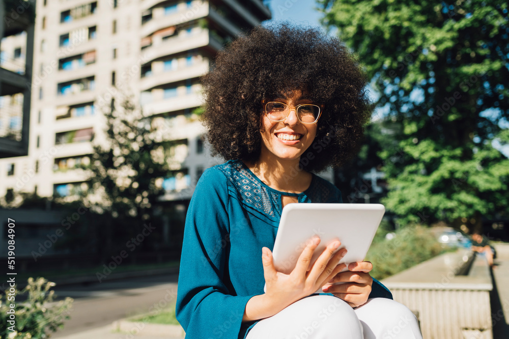 Smiling freelancer with digital tablet on sunny day Smiling freelancer with digital tablet on sunny day
