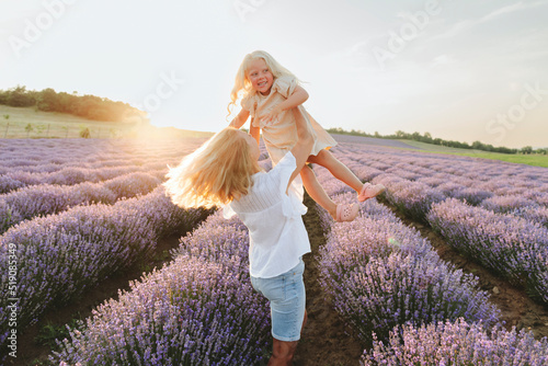 Playful mother enjoying with daughter in lavender field