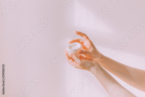 Women's hands hold a cosmetic copy space cream . An article about care cosmetics. Hand cream.