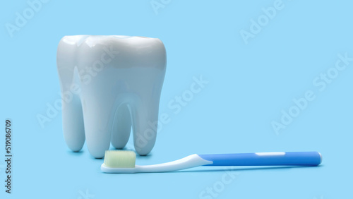 False teeth and toothbrush on a blue background.